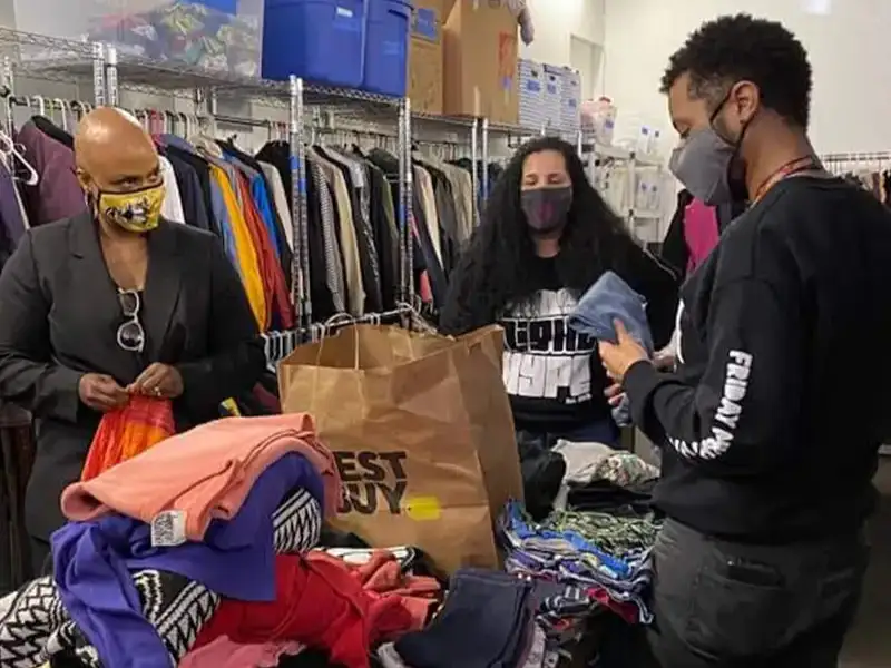 Three people organizing clothing